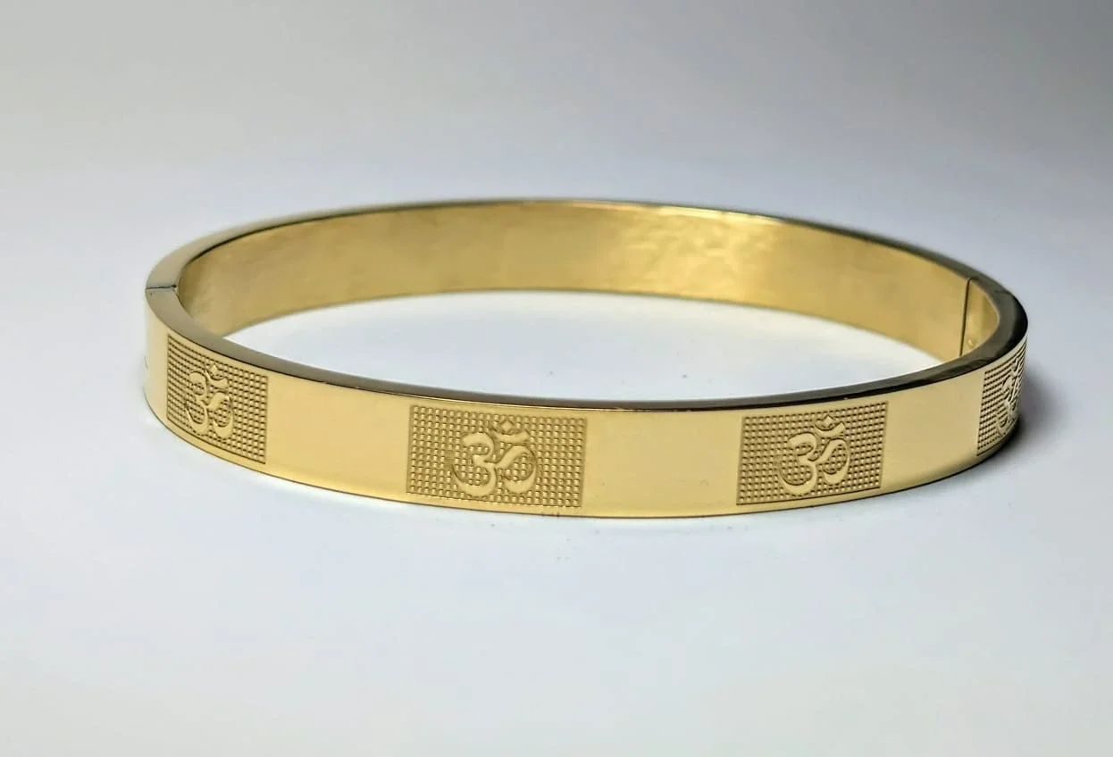 A gold-toned Om-pattern kada